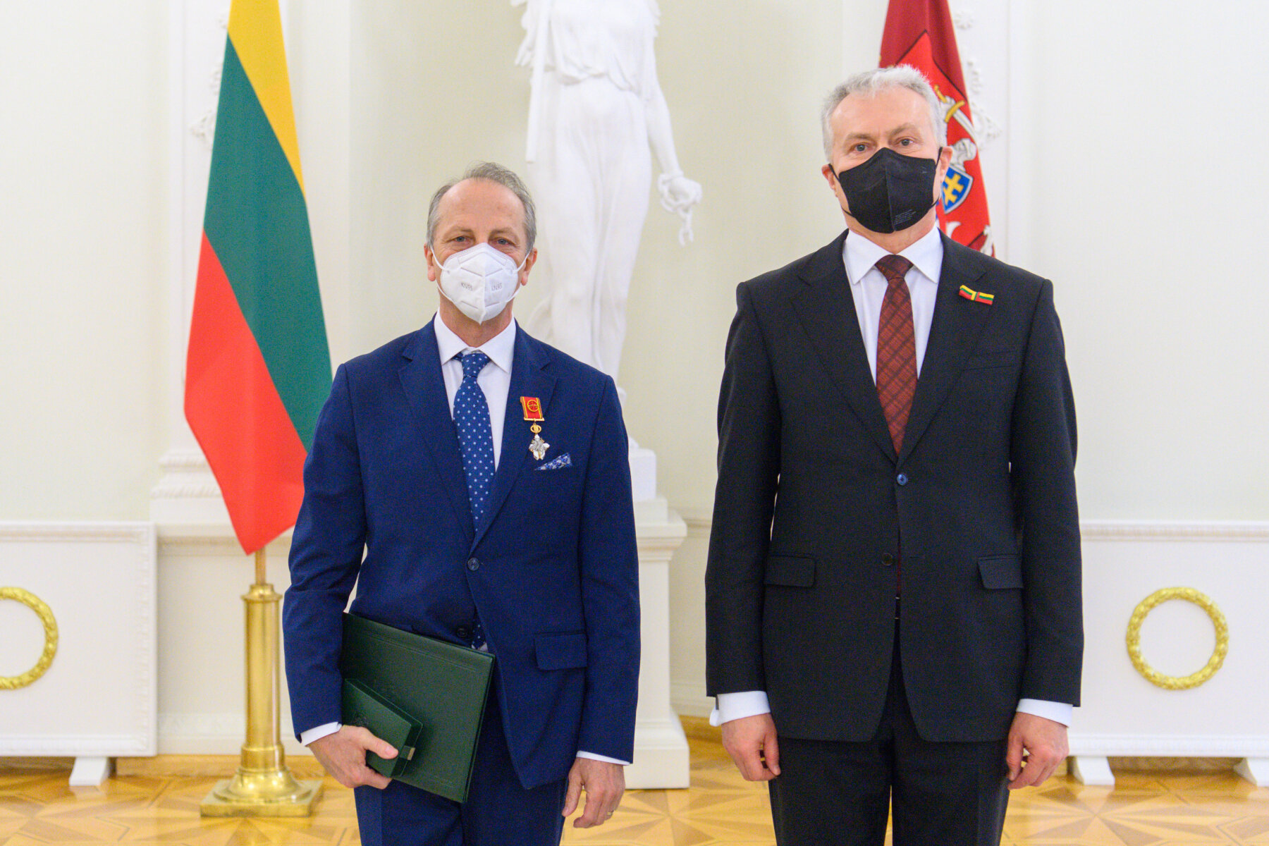 dw&oacute;ch mężczyzn w garniturach na tle flag